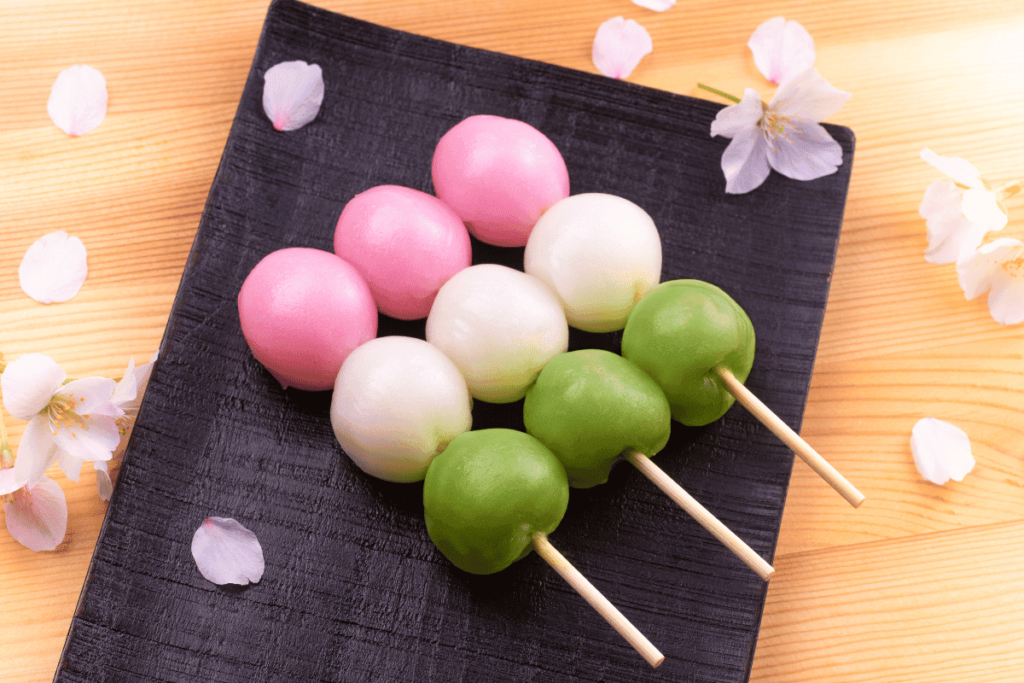 3 palitinhos de sanshoku dango sobre um prato.