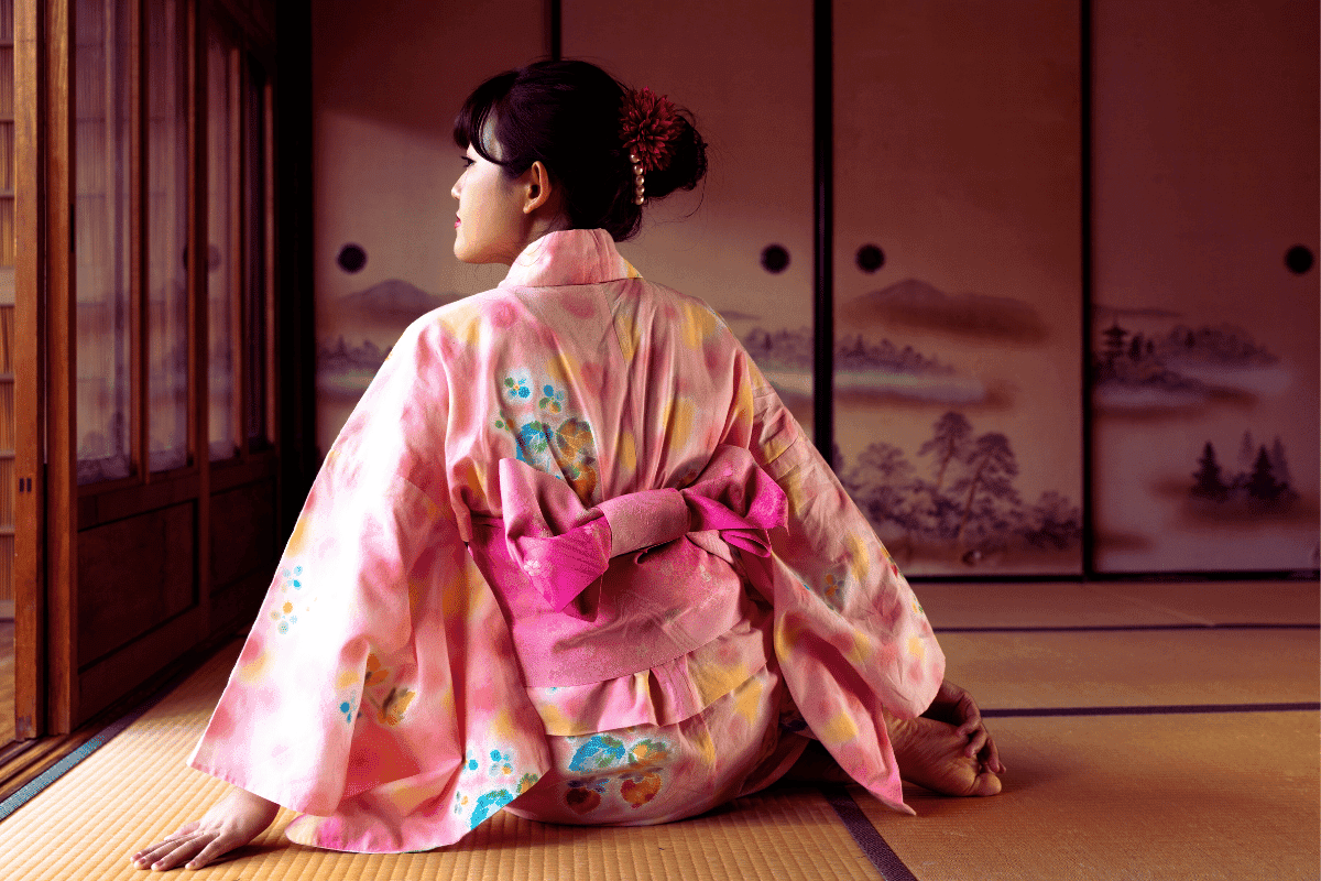 mulher sentada de costas, vestindo um yukata cor de rosa